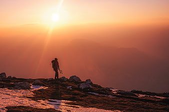 Silhouette of Hiker on Mountain Ridge at Golden Sunset