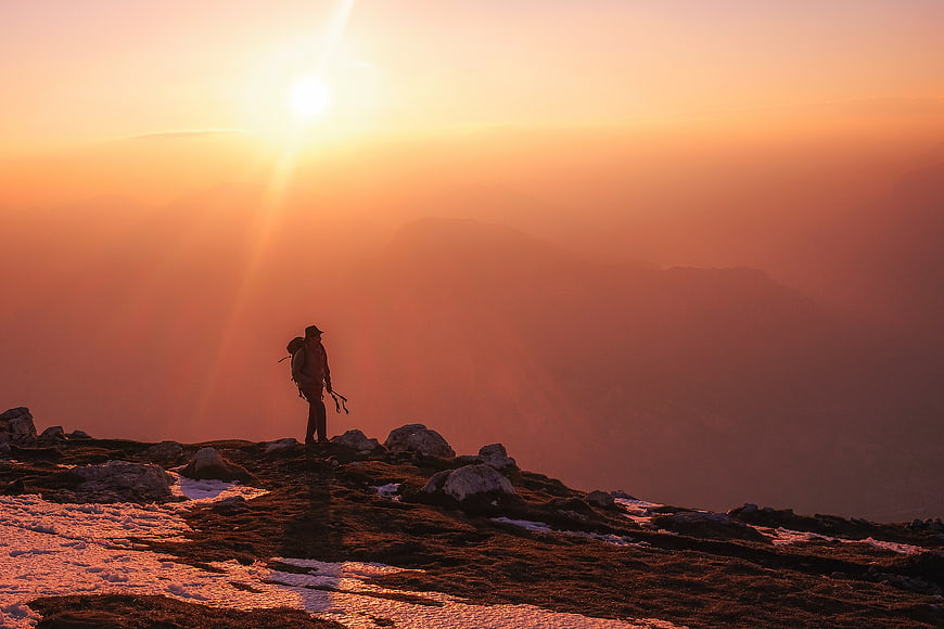 Silhouette of Hiker on Mountain Ridge at Golden Sunset