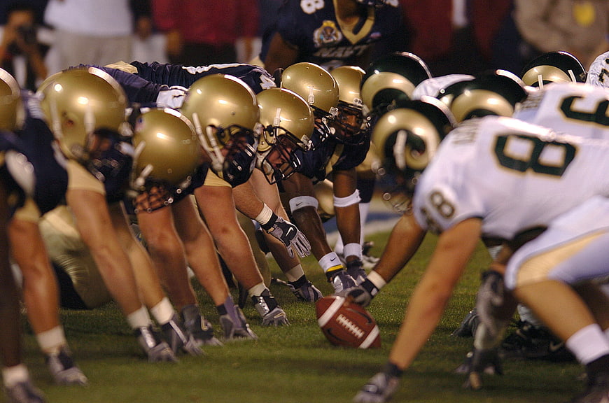 American football teams lined up at scrimmage on field