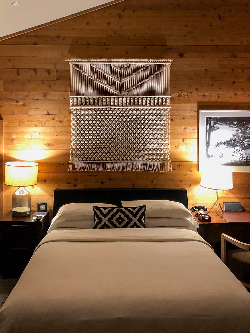 Cozy Cabin Bedroom with Macrame Wall Art and Wood Paneling
