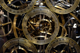 Close-up of intricate brass astronomical clock gears and dials