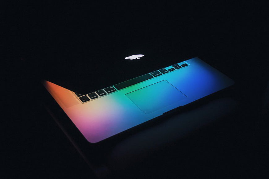 Illuminated MacBook with Rainbow Gradient in Dark Setting