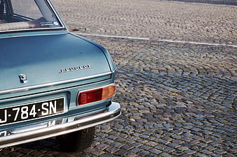 Rear View of Vintage Blue Peugeot on Cobblestone Street