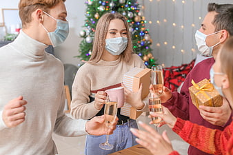 Friends celebrating Christmas with masks and gifts