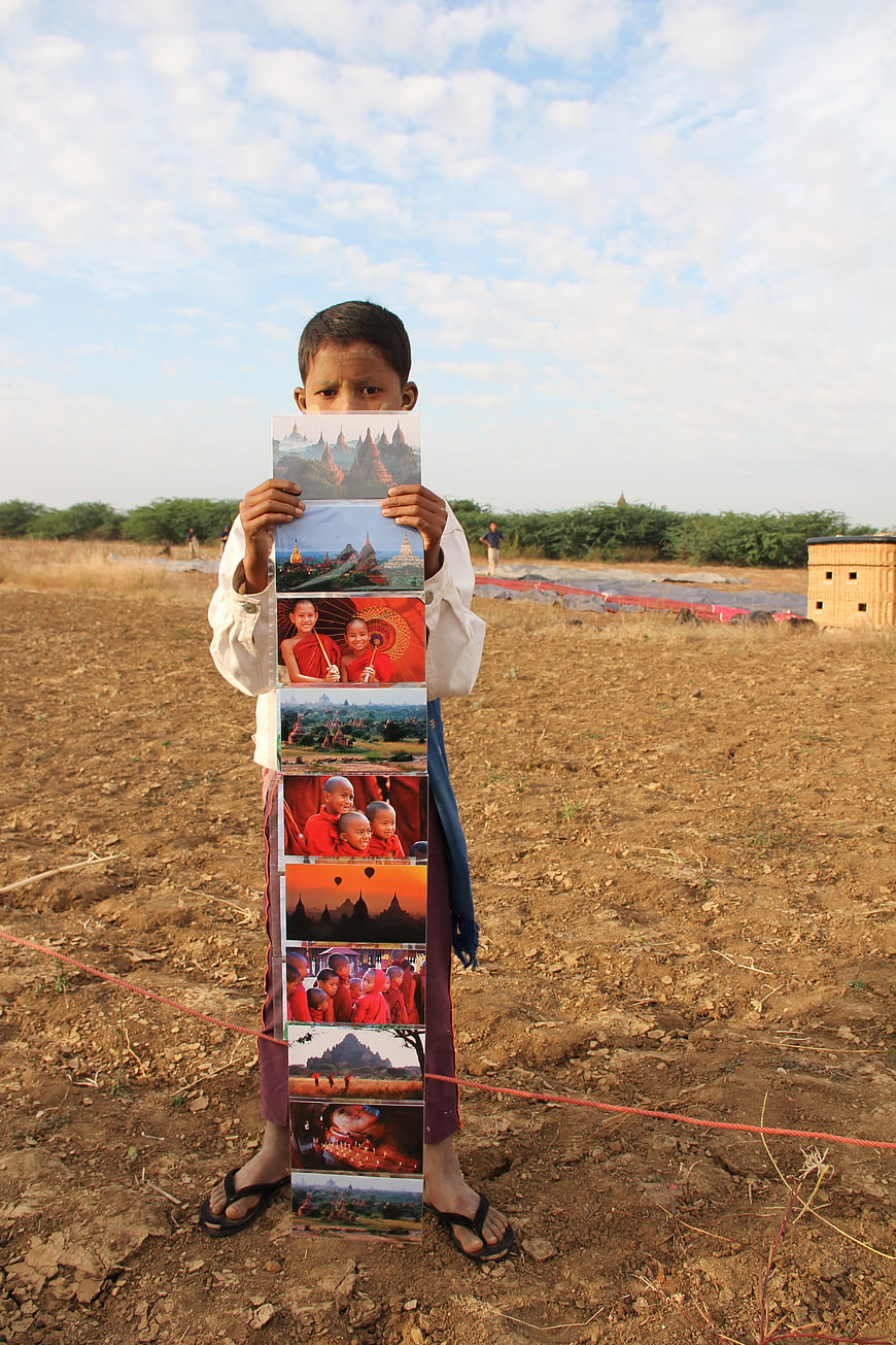 Young boy holding postcards in Bagan, Myanmar