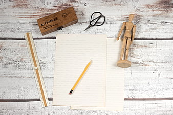 Top view of school supplies on white wooden background