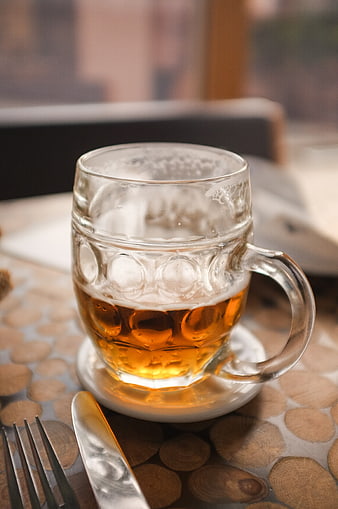 Half-full glass of beer on wooden table