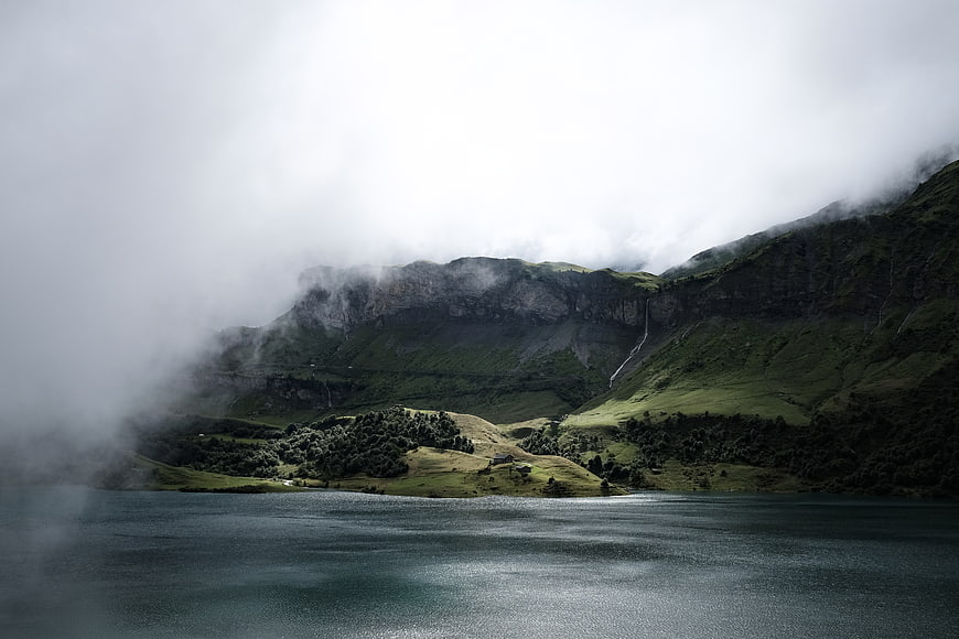 Misty Mountain Lake Landscape with Waterfall and Fog