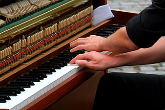 Close-up of hands playing an open grand piano