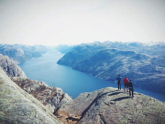 Hikers on Mountain Peak Overlooking Fjord