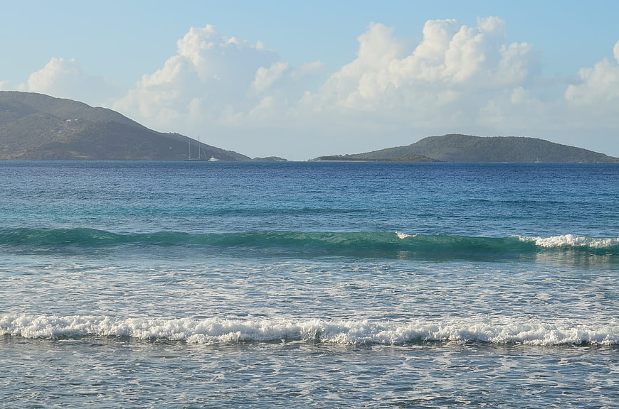 Serene ocean waves rolling toward shore with distant islands