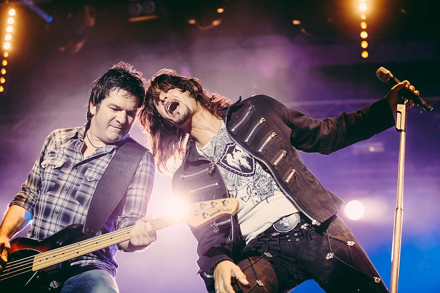 Rock band performing live on stage with guitar and microphone