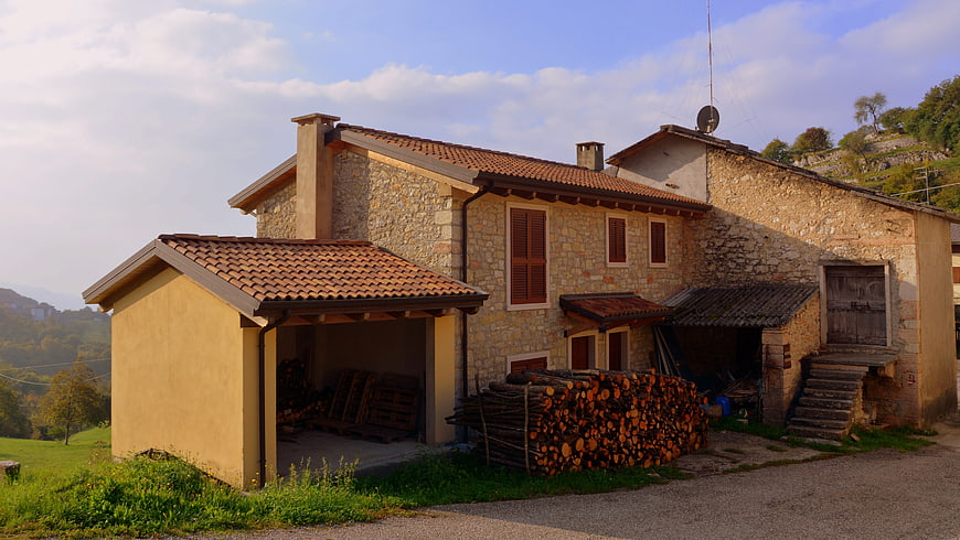 Rustic stone farmhouse with woodpile in Italian countryside