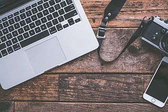 Laptop, Vintage Camera, and Smartphone on Rustic Wooden Desk