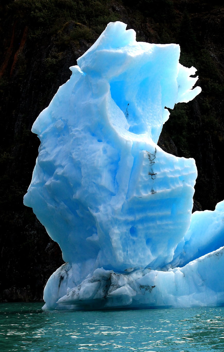 Vibrant Blue Iceberg Floating in Turquoise Water