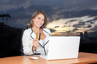 Smiling Business Woman Holding Credit Card at Laptop