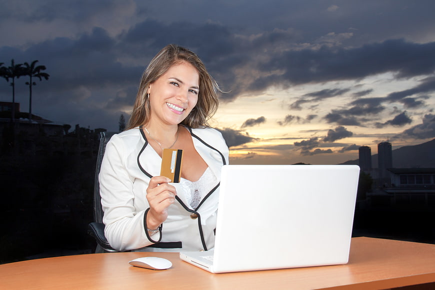 Smiling Business Woman Holding Credit Card at Laptop