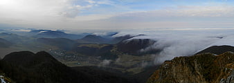 Panoramic mountain landscape with sea of clouds and valley village