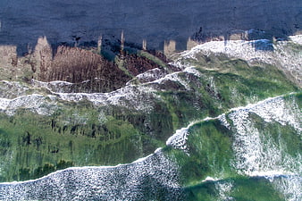 Aerial View of Green Ocean Waves Crashing on Sandy Beach