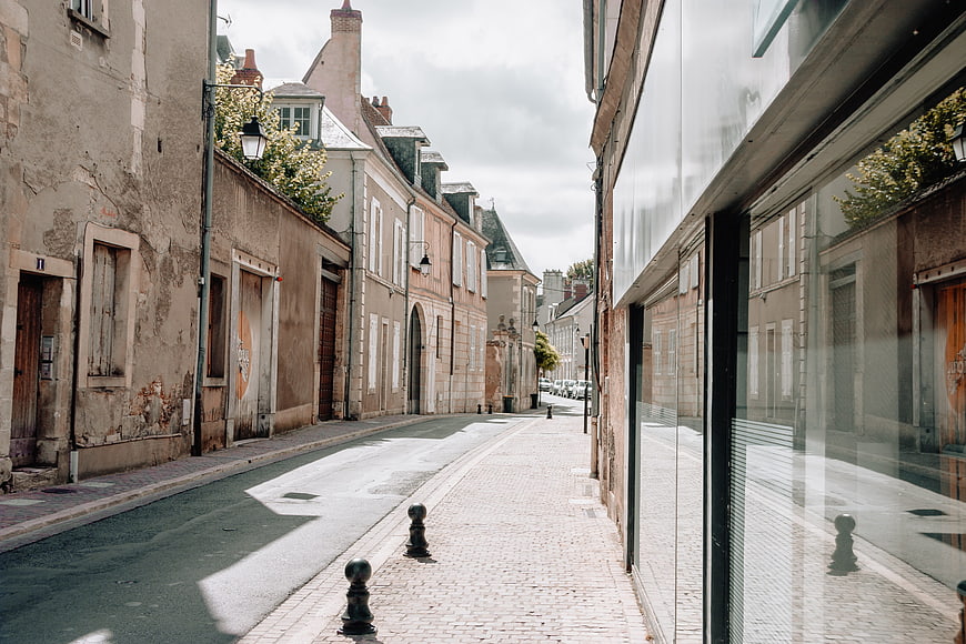 Quiet cobblestone street in old European town with modern glass facade