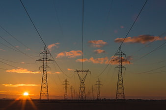 Silhouetted Power Lines Against Golden Sunset Sky