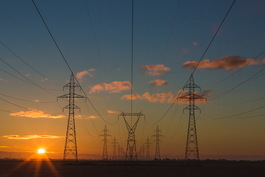 Silhouetted Power Lines Against Golden Sunset Sky