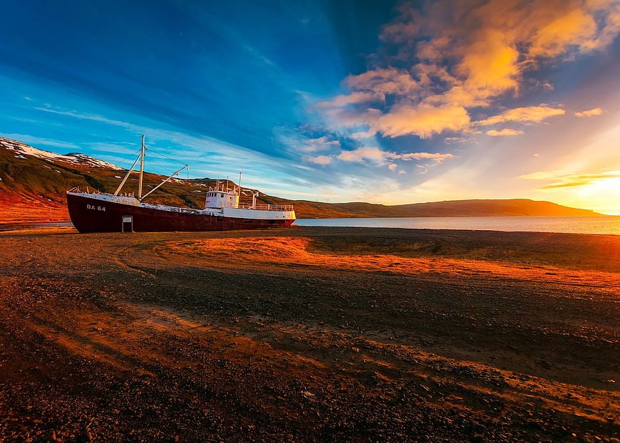 Abandoned Cargo Ship on Rocky Shore at Sunset