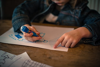 Child Drawing with Blue Marker on Paper
