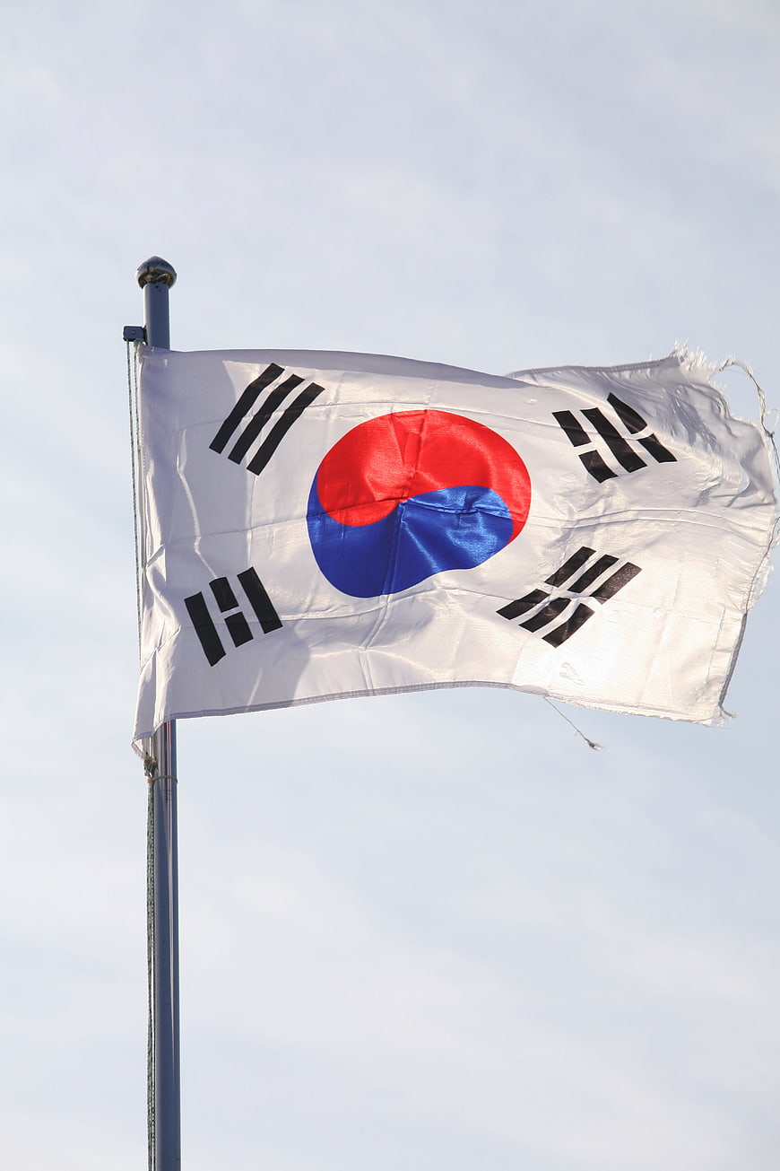 South Korea National Flag Waving on Pole Against Blue Sky