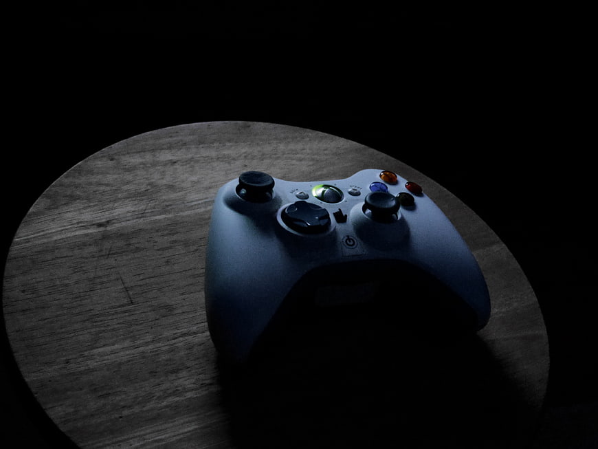 Dark moody Xbox controller on wooden surface