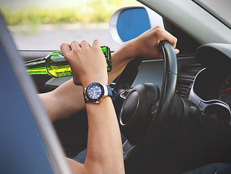 Man drinking beer while driving car close up