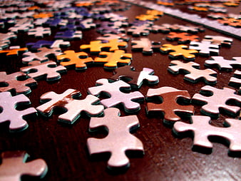 Scattered Jigsaw Puzzle Pieces on Dark Wooden Table
