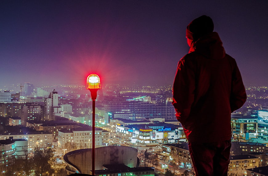 Silhouette of Man Looking at City Lights at Night