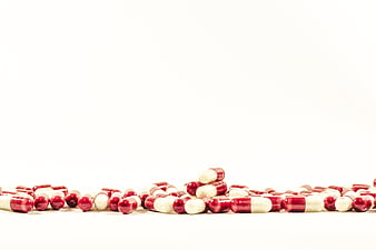 Red and white capsules on white background with copyspace