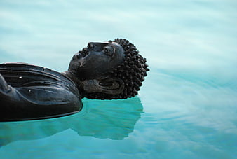 Serene Buddha Statue Floating in Turquoise Water