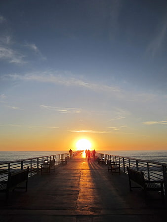 Silhouettes of People Walking on Pier at Sunset