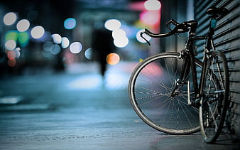 Black Bicycle Parked on City Street at Night with Bokeh Lights