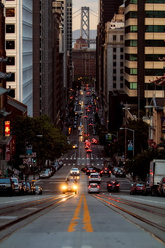 San Francisco Downtown Street View with Traffic and Bay Bridge at Dusk
