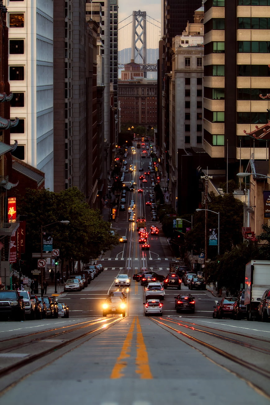 San Francisco Downtown Street View with Traffic and Bay Bridge at Dusk