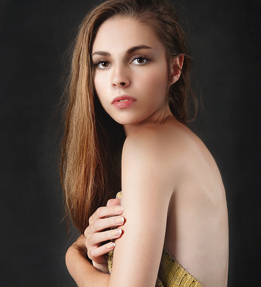 Beautiful young woman portrait with bare shoulders and golden dress