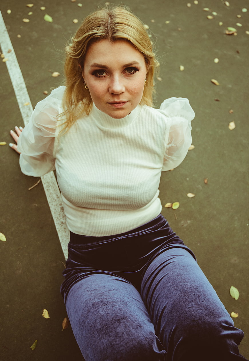 High Angle Portrait of Blonde Woman in White Top and Velvet Pants