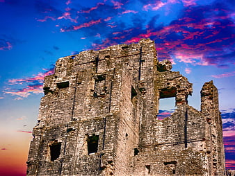Dramatic Stone Castle Ruins Against Vibrant Sunset Sky