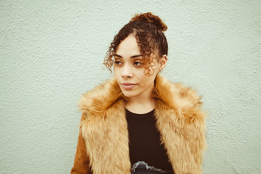 Woman in Fur Vest Against Textured Wall
