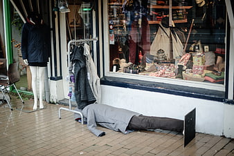 Mannequin lying on pavement outside clothing store window