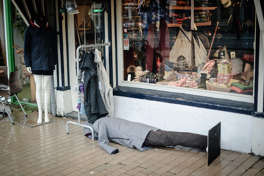 Mannequin lying on pavement outside clothing store window