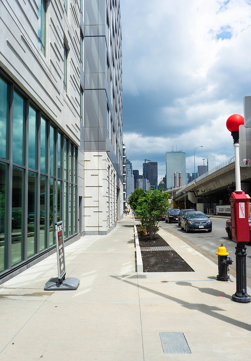 Modern city street with skyscrapers and cloudy sky
