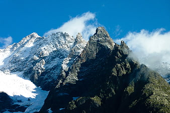 Snow-Covered Mountain Peaks Under Blue Sky