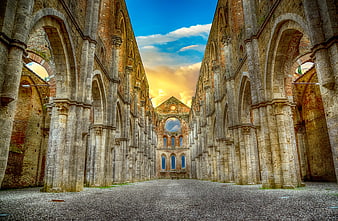 Interior of a roofless medieval abbey ruin with stone arches
