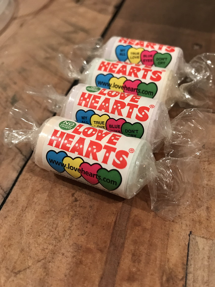 Love Hearts candy rolls on wooden table