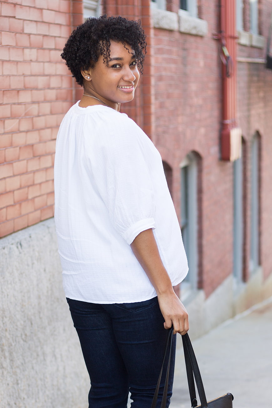 Smiling young woman with curly hair walking outdoors